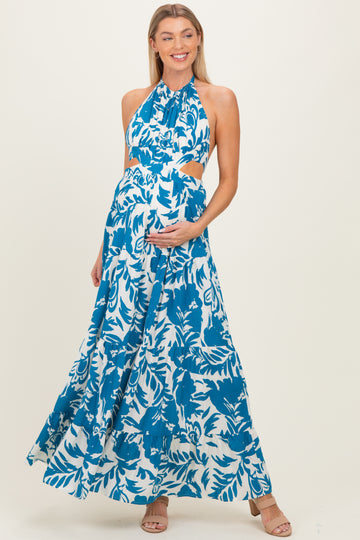 woman wearing a blue and white floral print halter maternity maxi dress and holding her baby bump