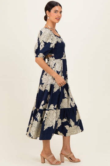 woman wearing a navy blue floral maxi dress with puff sleeves and a smocked bodice