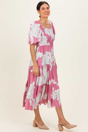 woman wearing a pink floral midi dress with puff sleeves and a square neckline, paired with nude heels