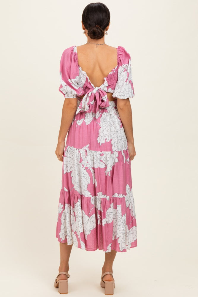 woman wearing a pink floral midi dress with puff sleeves and a tie back, showing a low back detail