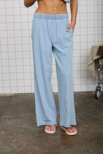 woman wearing light blue wide-leg lounge pants with an elastic waistband and side pockets