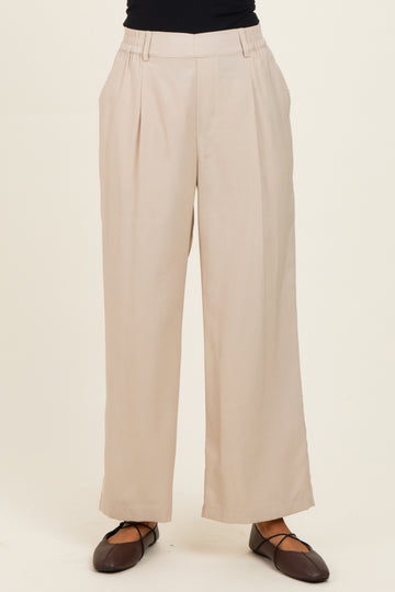 woman wearing beige wide-leg trousers with a high waist and side pockets