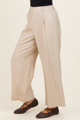woman wearing beige wide-leg trousers and brown ballet flats