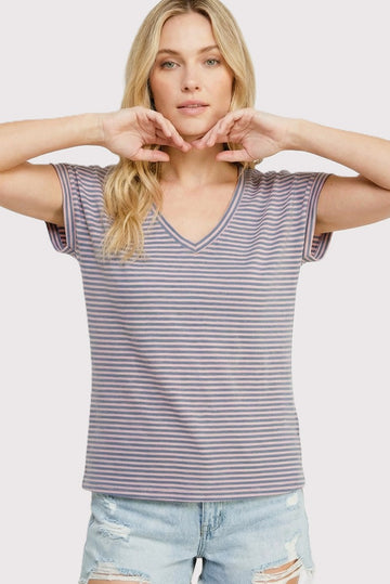 woman wearing a purple and white striped short sleeve v-neck t-shirt with a relaxed fit and distressed denim shorts
