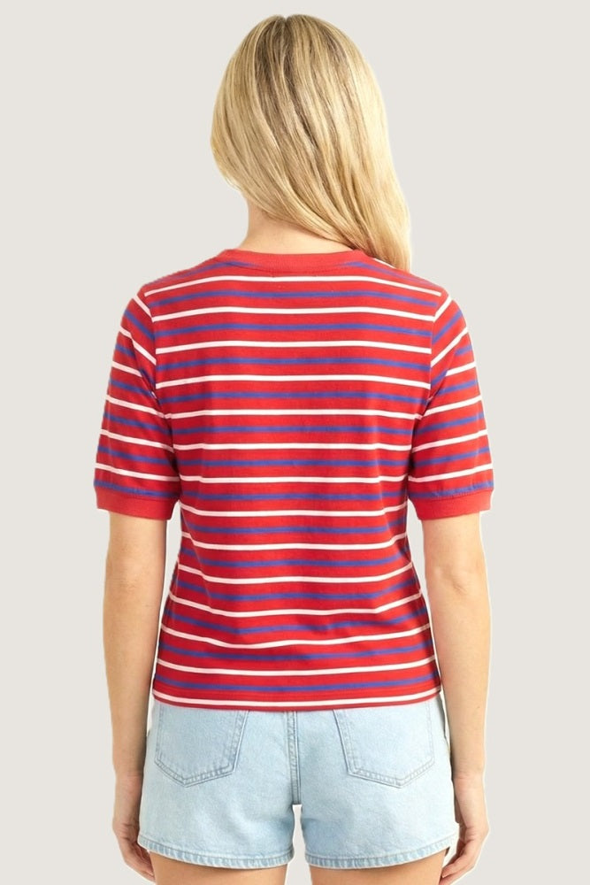woman wearing a red and blue striped short sleeve t-shirt and light blue denim shorts, showing the back view