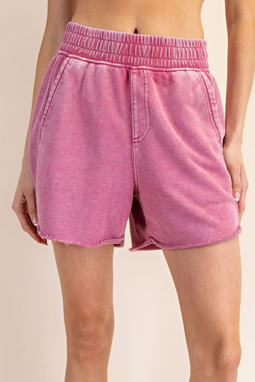 woman wearing pink tie-dye lounge shorts with an elastic waistband and frayed hem