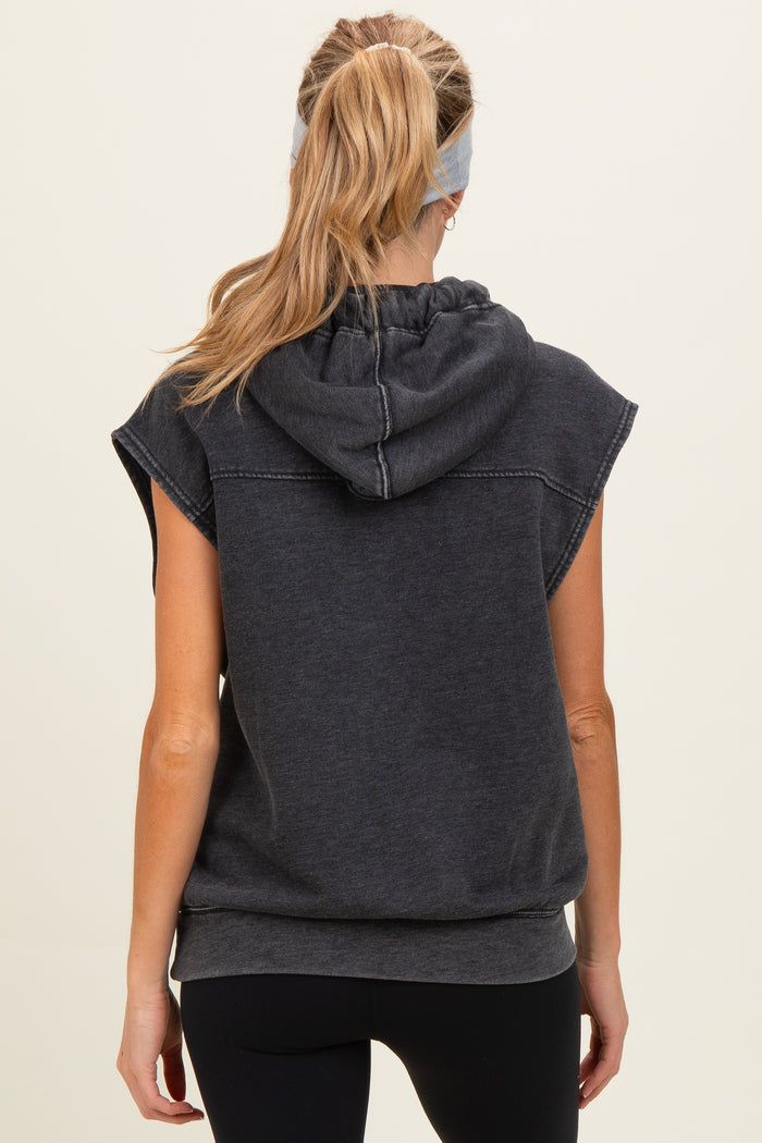 woman wearing a dark gray maternity hooded sweatshirt with short sleeves and a relaxed fit, showing the back view