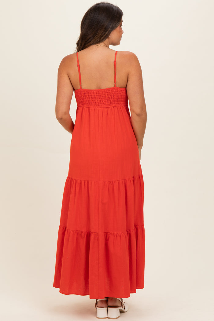 woman wearing a red maternity maxi dress with a smocked bodice and tiered skirt, seen from the back