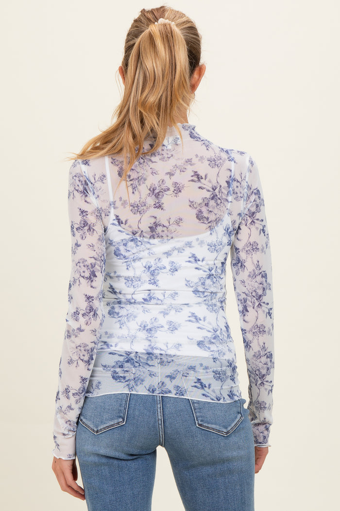 woman wearing a sheer purple floral long sleeve maternity top, viewed from the back