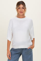 woman wearing a white short sleeve maternity sweater with relaxed fit and a visible baby bump