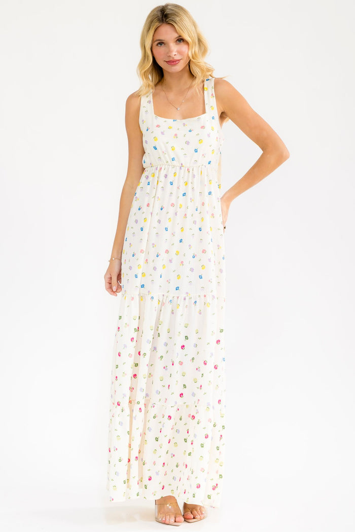 woman wearing a floral print maxi dress with a square neckline and flowy skirt