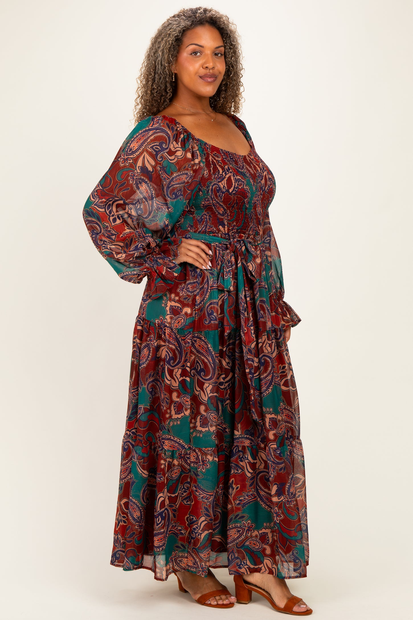 plus size woman wearing a bohemian maxi dress with paisley print and balloon sleeves, tied at the waist