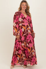 woman wearing a maternity plus floral wrap maxi dress with long sleeves and a deep V-neckline