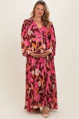 woman wearing a brown floral maxi maternity dress and holding her baby bump