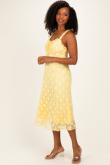 woman wearing a yellow lace midi dress with a scoop neckline and spaghetti straps