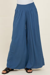 woman wearing blue wide-leg pants with a smocked waistband and a flowy silhouette
