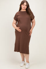 woman wearing a brown short sleeve maternity dress with a pocket and side slits, cradling her baby bump