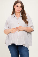 woman wearing a striped maternity plus button-up shirt and holding her baby bump while smiling