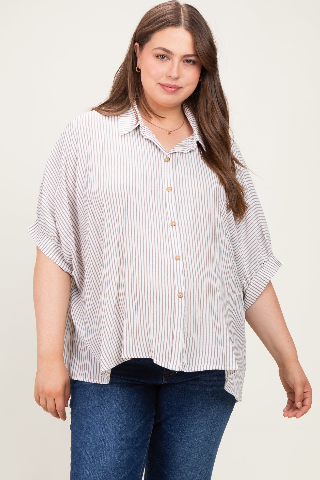 woman wearing a striped button-up maternity plus shirt with rolled sleeves and relaxed fit
