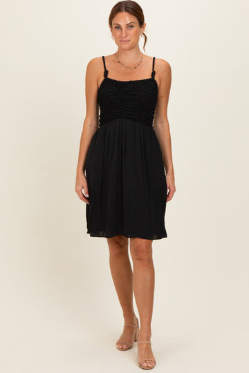woman wearing a black spaghetti strap dress with a smocked bodice and a flowy skirt