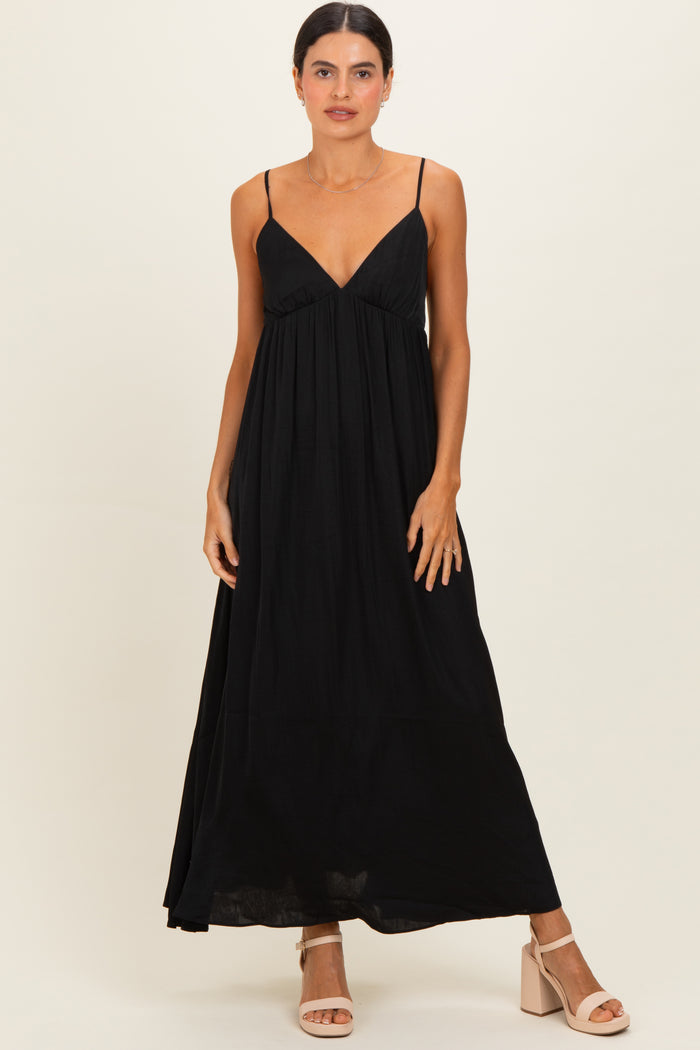 woman wearing a black sleeveless maxi dress with a v-neckline and flowy silhouette