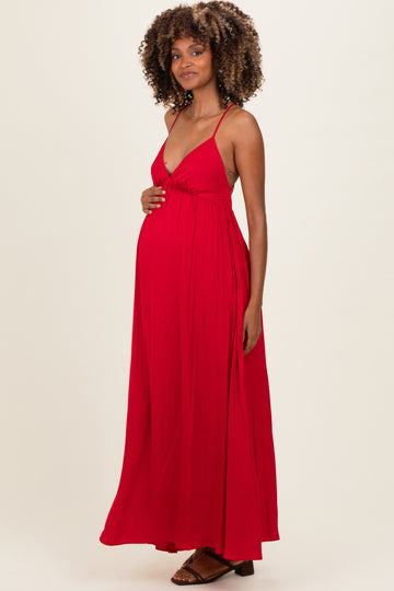 woman wearing a red maxi maternity dress with spaghetti straps and a visible baby bump