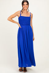 woman wearing a vibrant blue maxi dress with a smocked bodice and thin straps