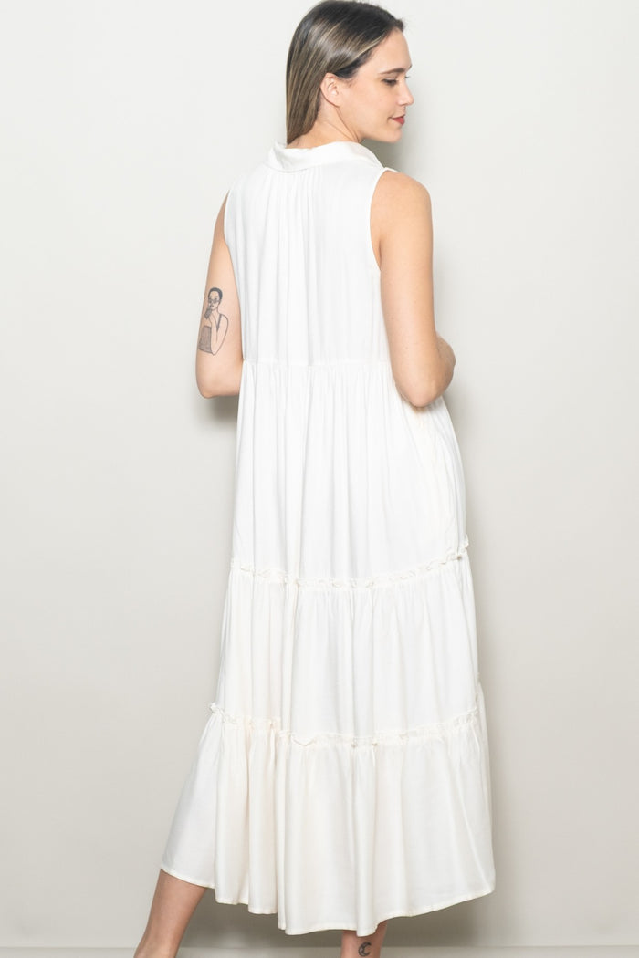 woman wearing a white sleeveless midi dress with a tiered design and relaxed fit, showing the back view