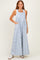 woman wearing a light blue floral maxi dress with pockets and a white tank top underneath