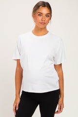 woman wearing a white short sleeve maternity t-shirt and black leggings, showing her baby bump