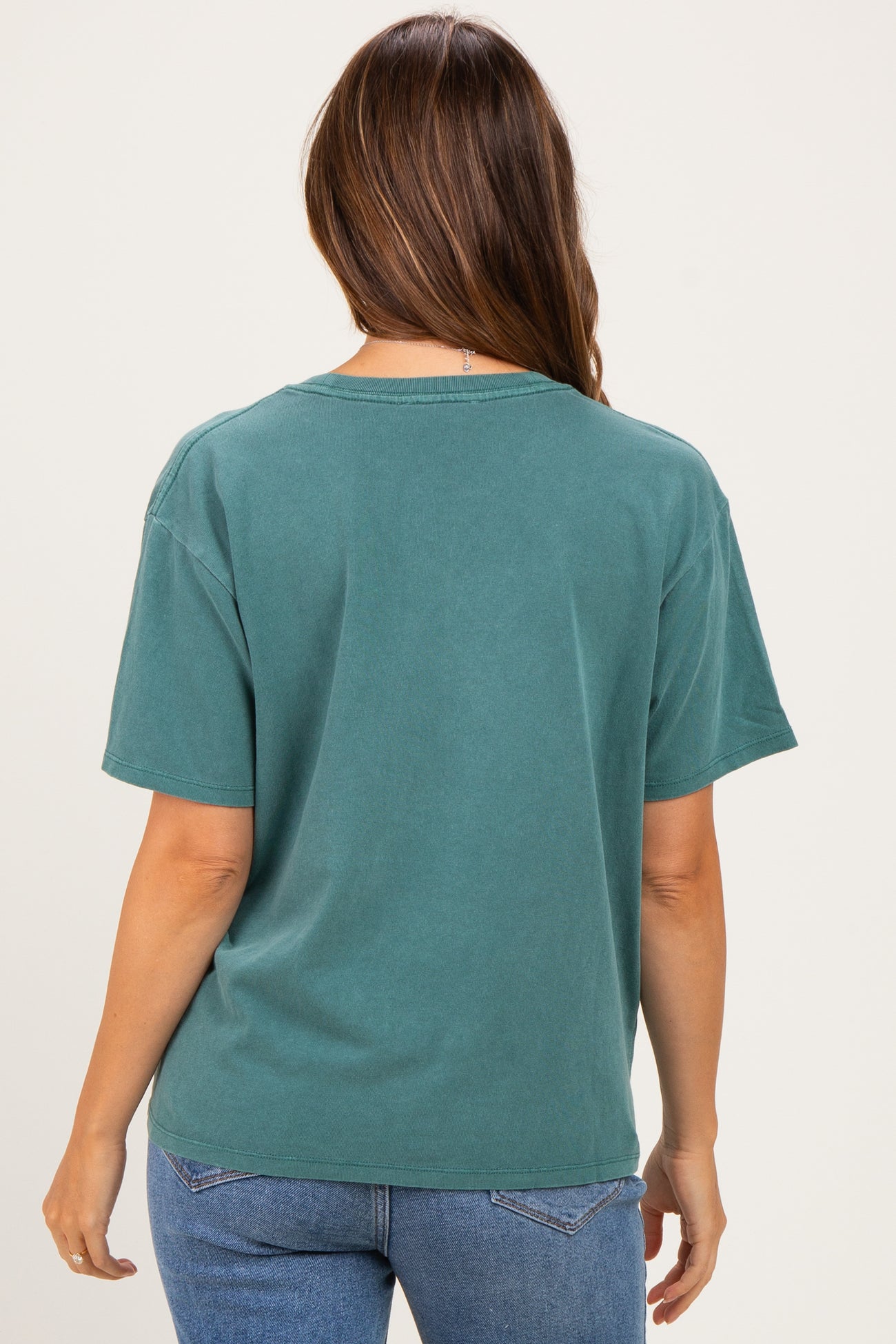 woman wearing a teal oversized maternity t-shirt with short sleeves and a relaxed fit