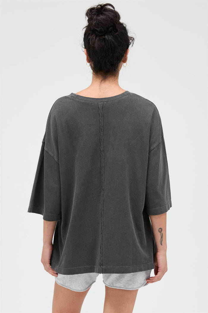 woman wearing a loose-fitting dark grey oversized t-shirt with a back seam detail