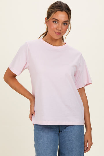 woman wearing a pink short sleeve t-shirt paired with blue jeans