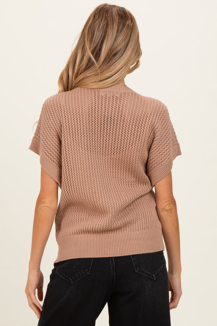 woman wearing a beige knit maternity sweater with short sleeves, shown from the back