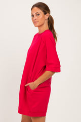woman wearing a bright pink short sleeve dress with pockets, styled in a relaxed silhouette