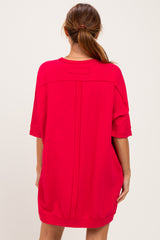 woman wearing a loose-fitting bright red oversized dress with short sleeves and a striped back detail