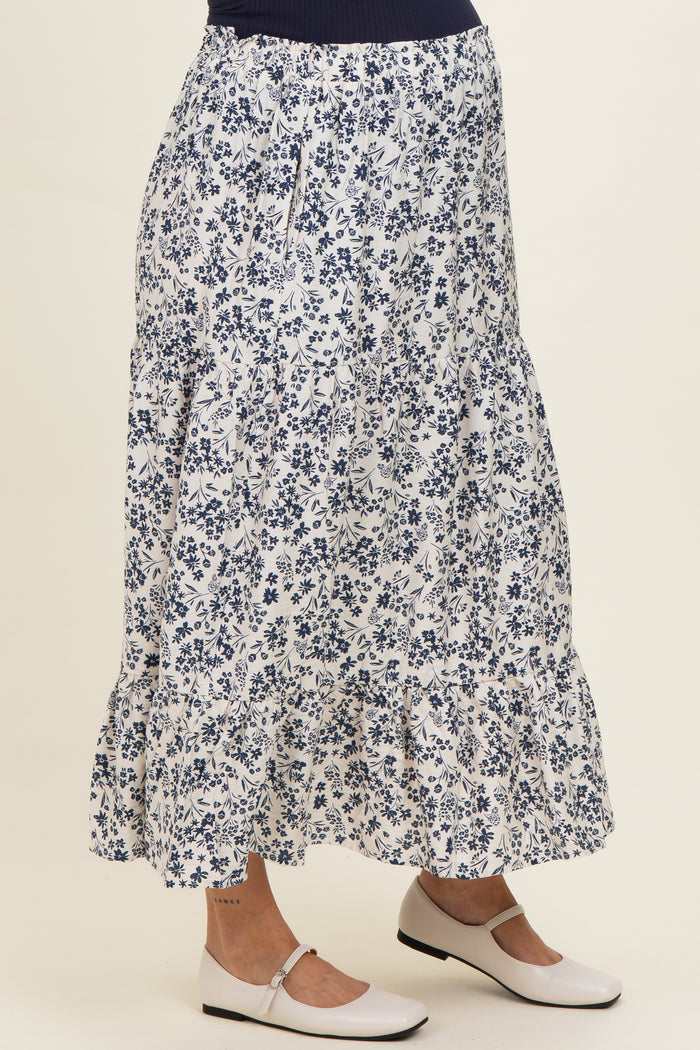 woman wearing a navy floral maternity maxi skirt with tiered ruffles