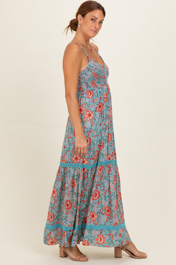woman wearing a blue floral maxi dress with spaghetti straps and a tiered skirt
