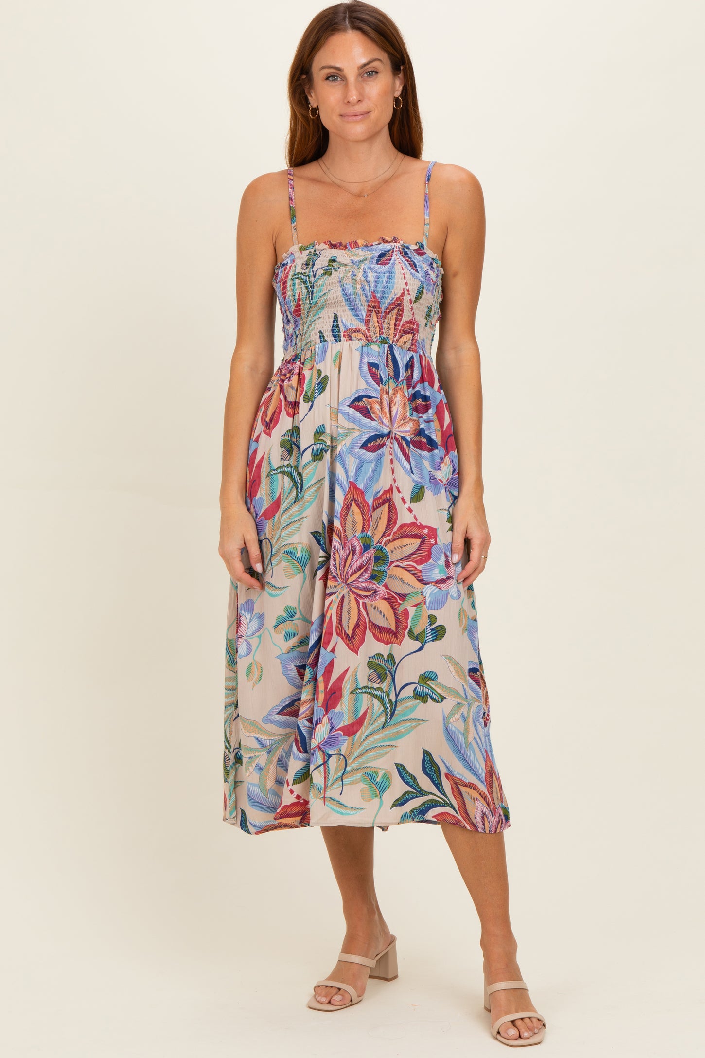 woman wearing a floral print midi dress with a smocked bodice and adjustable spaghetti straps