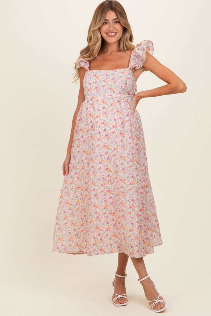 woman wearing a floral maternity maxi dress with puff sleeves and a fitted bodice, showcasing a baby bump