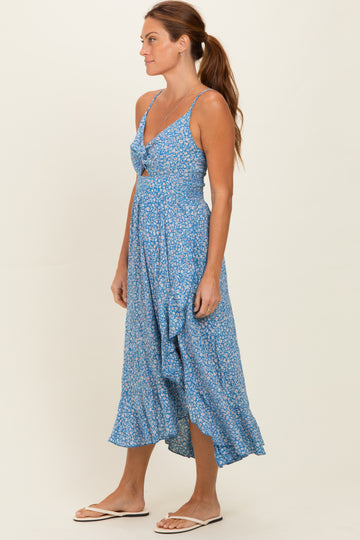 woman wearing a blue floral midi dress with a tie front and a flowy hem, standing sideways on a neutral background