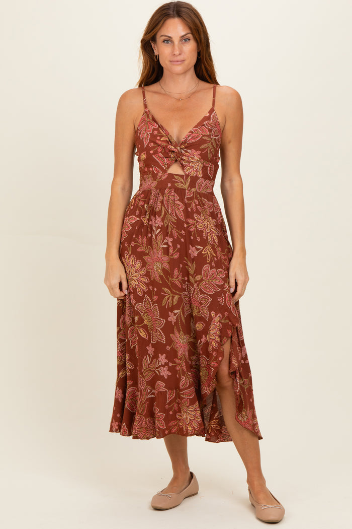 woman wearing a maroon floral midi dress with a knotted front and slits on the sides