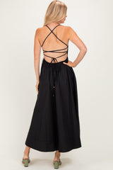 woman wearing a black maxi dress with a crisscross back and drawstring detailing