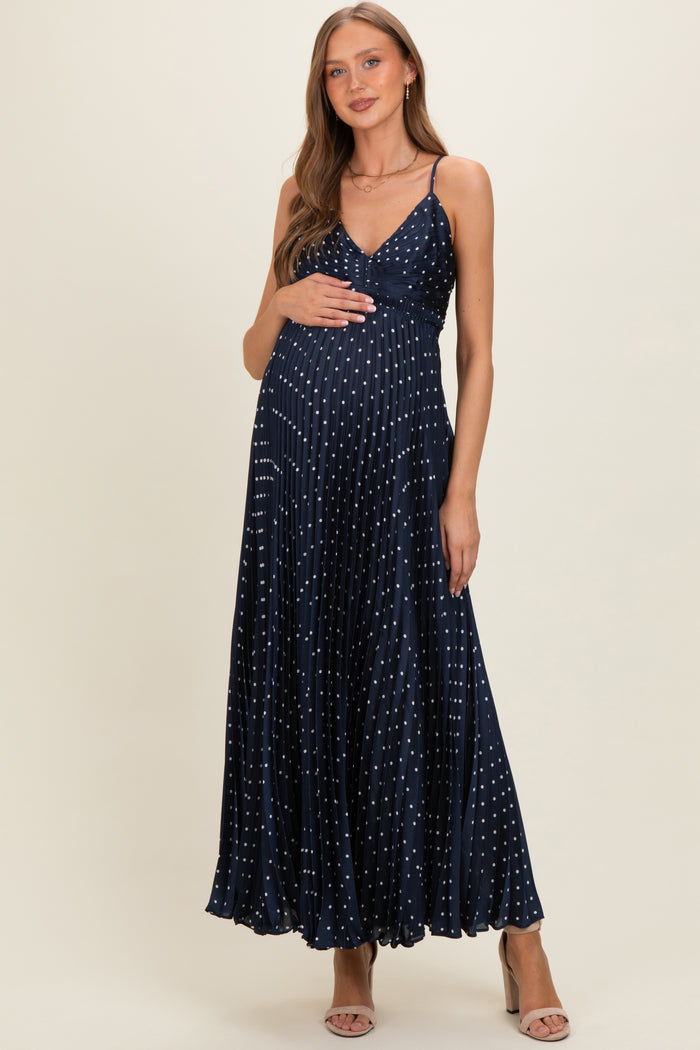 woman wearing a navy blue maternity maxi dress with silver polka dots and a baby bump visible