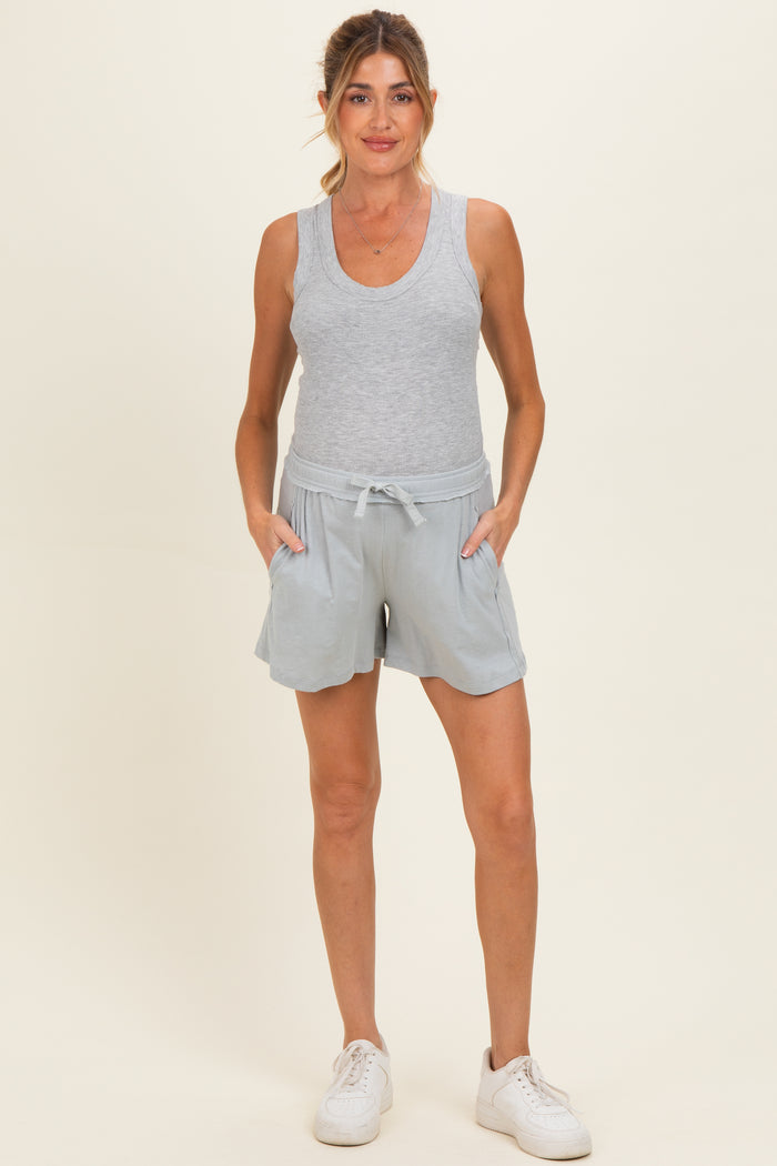 woman wearing a gray maternity tank top and light blue maternity shorts with pockets