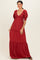 woman wearing a ruby red maxi dress with puff sleeves and tiered ruffles, smiling against a neutral background