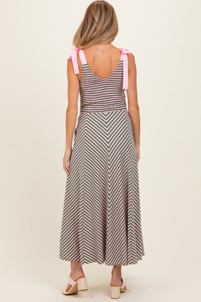 woman wearing a striped maternity dress with a fitted bodice and flared skirt, tied shoulder straps visible from the back