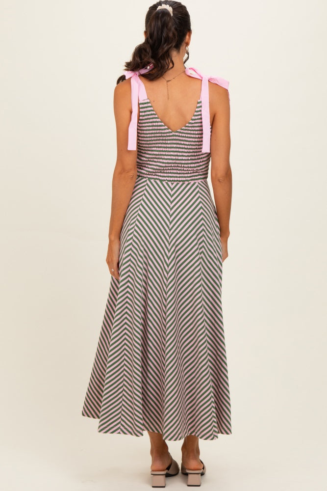 woman wearing a back view of a striped midi dress with a fitted bodice and pink tie straps