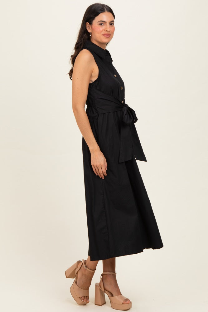 woman wearing a black button-up midi dress with a tie waist and heels