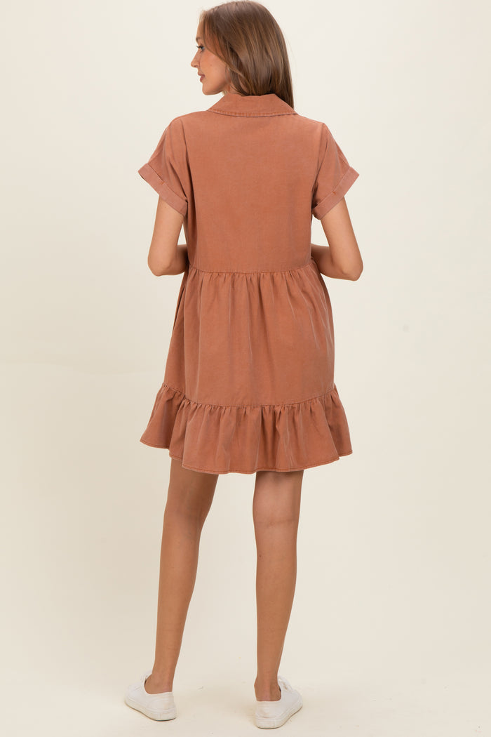 woman wearing a rust-colored short sleeve maternity dress with a tiered ruffle hem